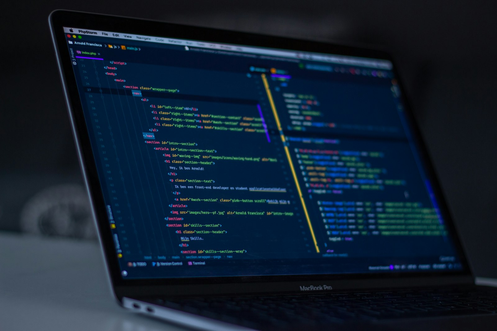 Code on a laptop screen in a dark room
